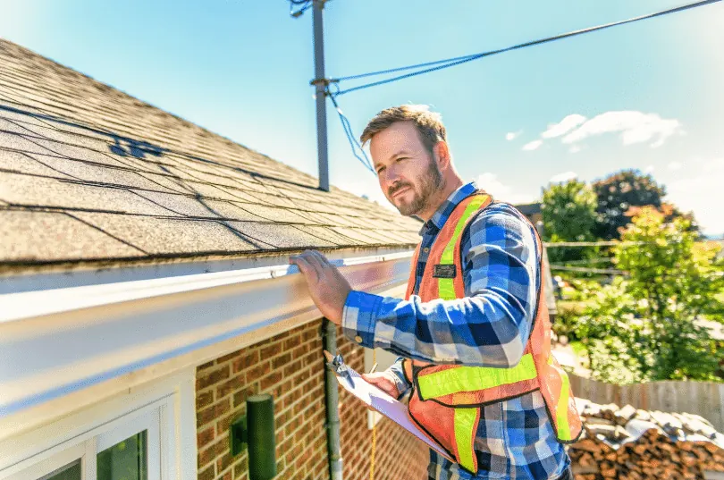 Roofing specialist checking the gutter line of a brick home