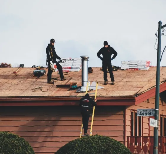 Crew working on a roof stripped to the decking during a replacement